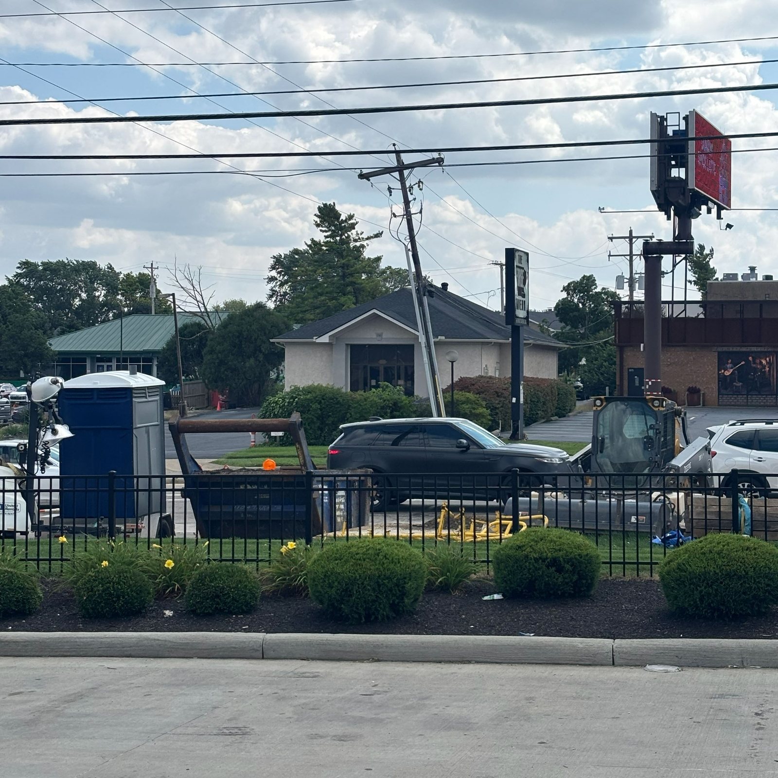 Skid steer and dumpster staged in a corner work zone